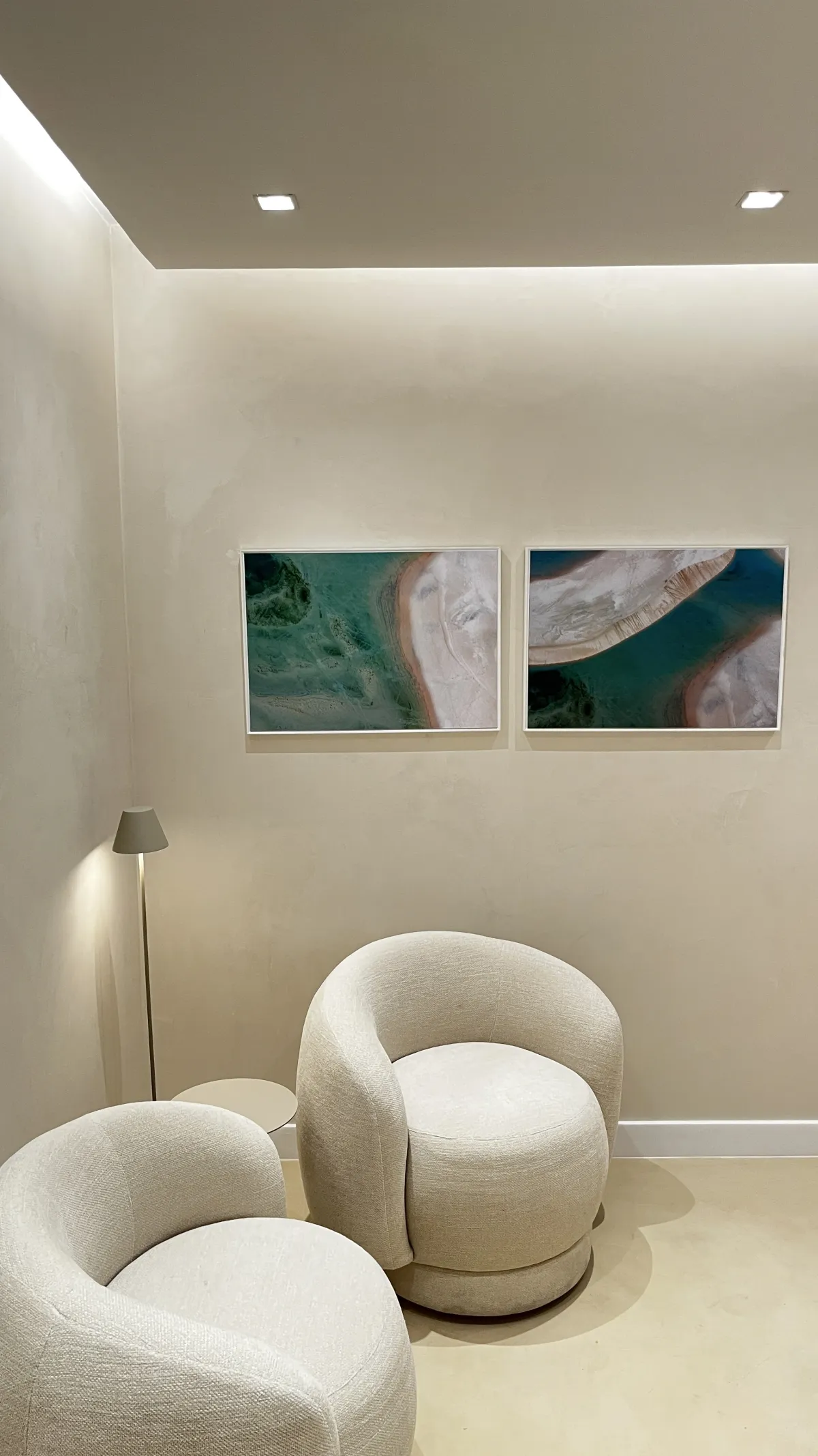 Sala de espera da CAIS com poltronas claras e quadros de paisagens costeiras